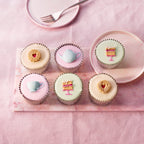Afternoon Tea Fairy Cakes, six pastel fondant cakes with handcrafted teacup, teapot, cake slice and heart biscuit sugar decorations on a pink board.